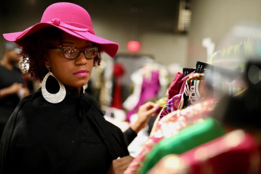 Kenya Buchanan examines her collection of original clothing backstage at Magic City Fashion Week. CW/ Joe Will Field