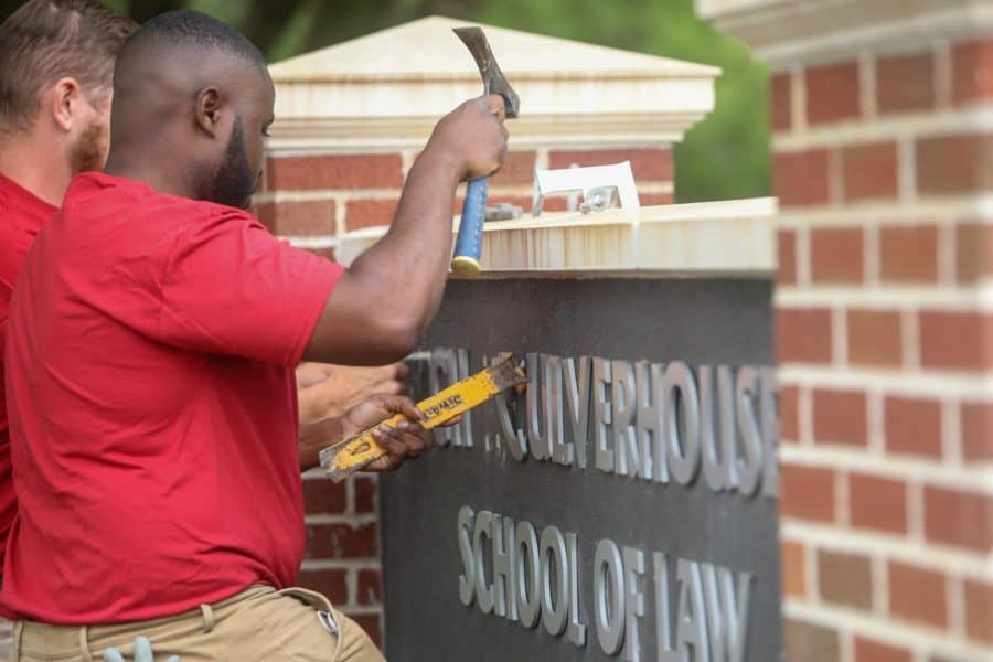 Groundskeepers remove Hugh F. Culverhouse, Jr. from UA law school sign.