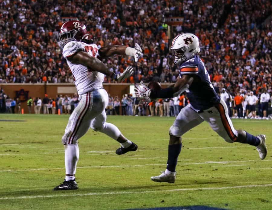 Junior running back Najee Harris reaches back for the football while Auburn linebacker Zakoby McClain hauls in the interception in the second quarter of the Iron Bowl. (CW / Hannah Saad)