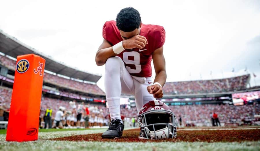 Alabama quarterback Bryce Young kneels in prayer before the Crimson Tide takes on Ole Miss at Bryant-Denny Stadium on October 2, 2021.