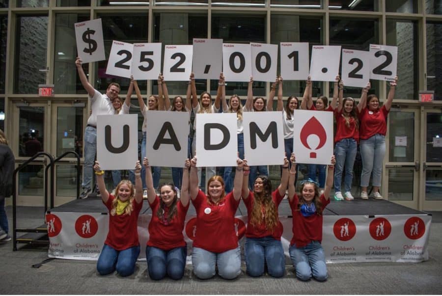 UADM members holding cardboard signs that read $252,001.22.