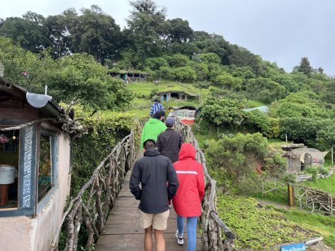 A photo of a study abroad group in a foreign country, going on what looks to be a hike in a somewhat tropical area. They have colorful coats.