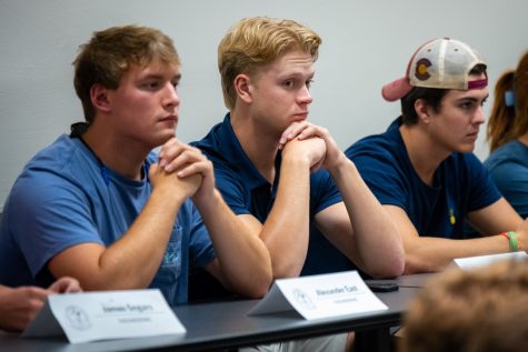 Three SGA members sit side by side at a table.