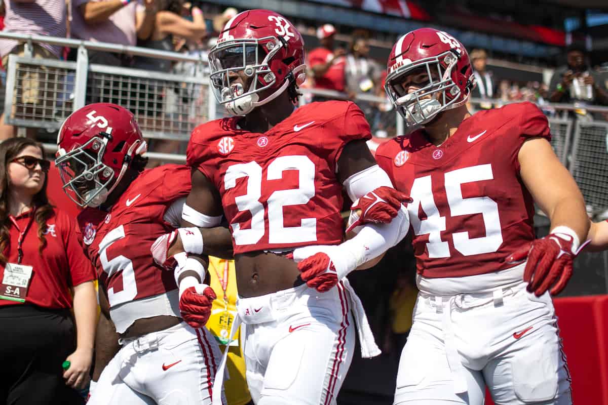 Alabama football players walk out to the field before a game.