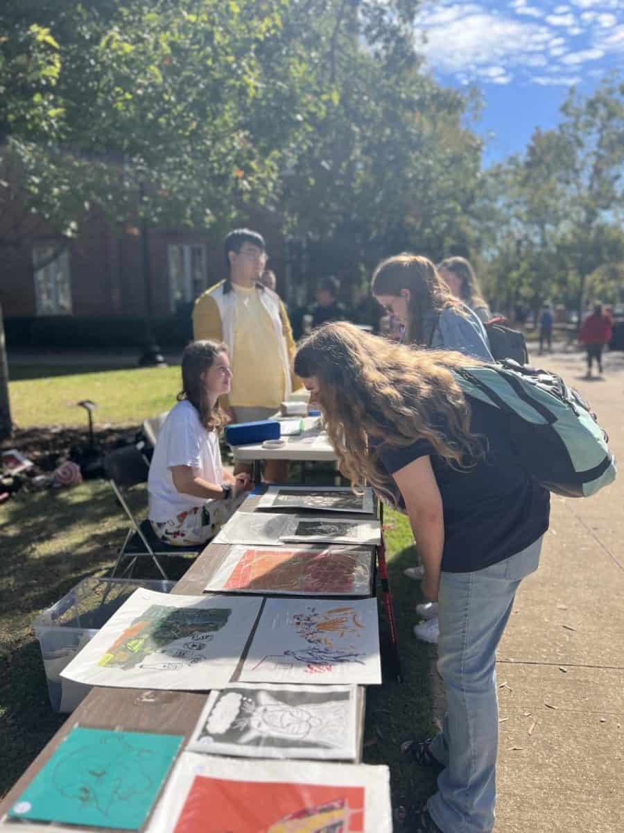 Students browse prints at the Print Sale event.