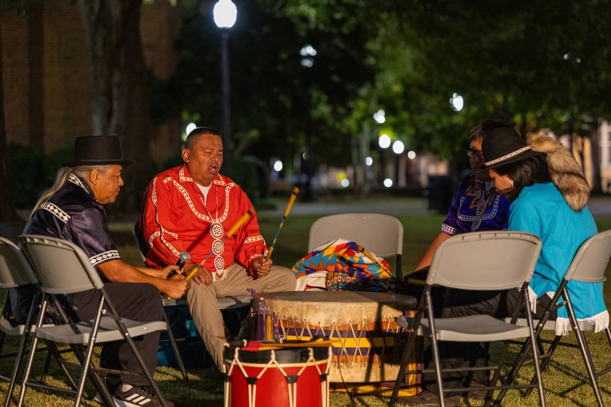 Dan Isaac, left, joins in drumming during a Native dance.