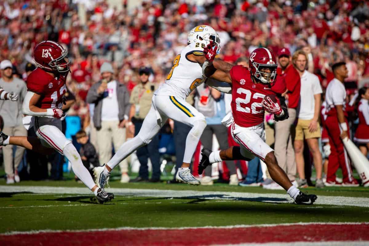 Alabama running back Justice Haynes (#22) attempts to stiff arm a Chattanooga defender to score a touchdown.