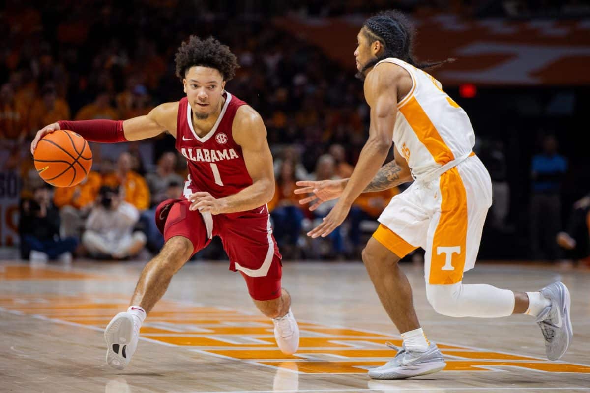 Alabama guard Mark Sears (#1) dribbles around a Tennessee defender.