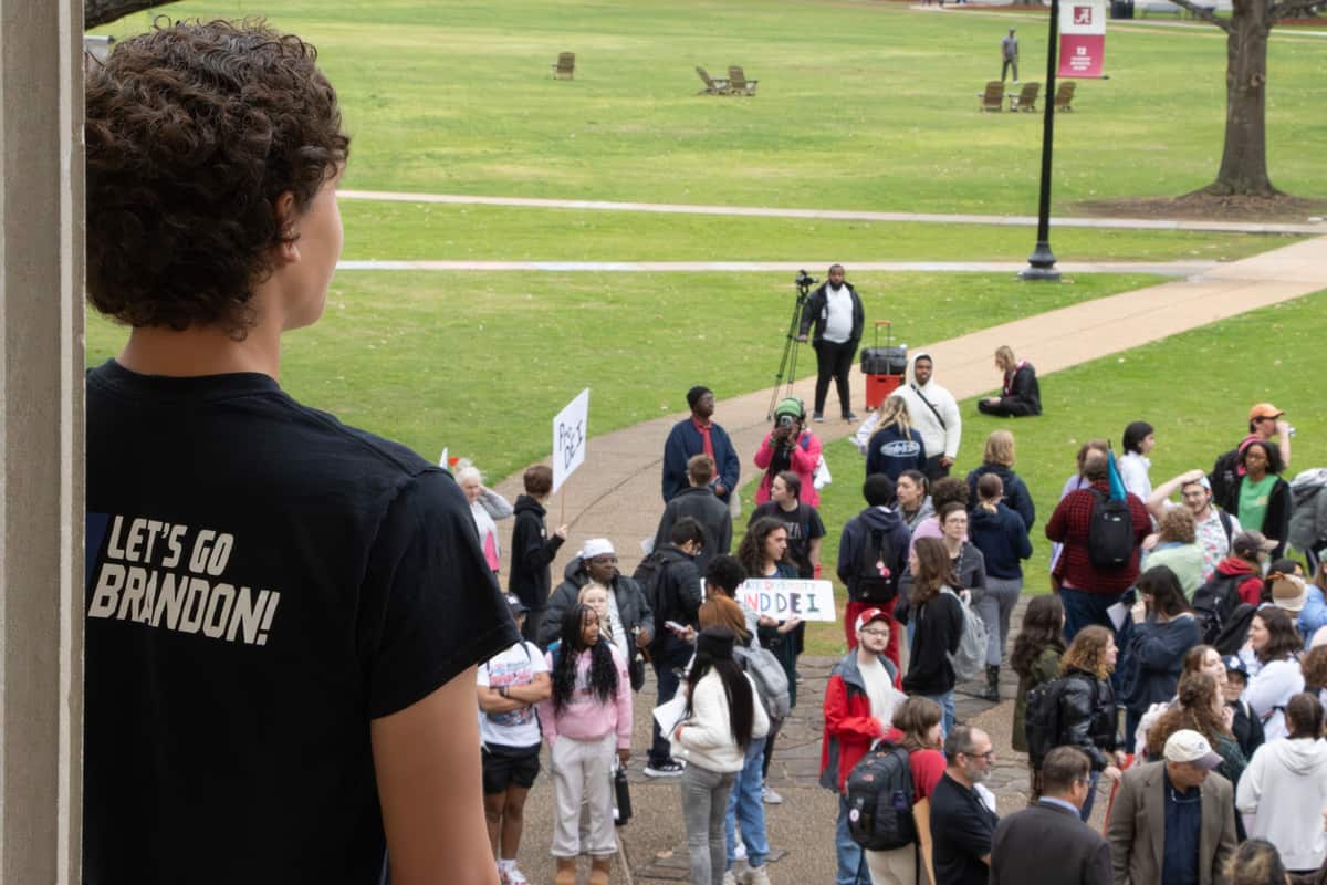 A+spectator+wearing+a+%E2%80%9CLet%E2%80%99s+Go+Brandon%E2%80%9D+shirt+at+the+DEI+protest+on+campus.