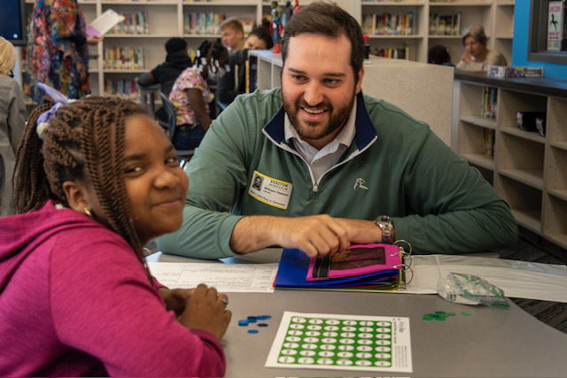 A Reading Allies volunteer works with a student.