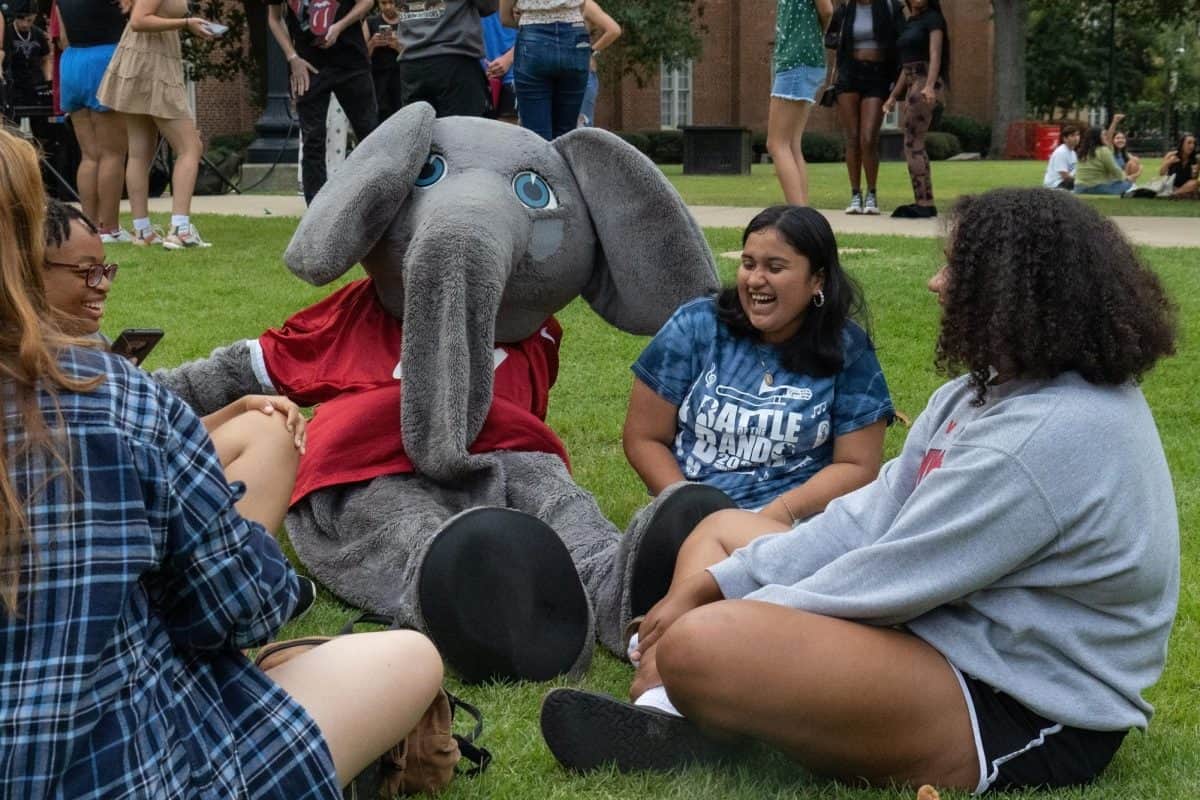 Students laughing with Big Al at the Hispanic Heritage Month kickoff in the Fall of 2023.