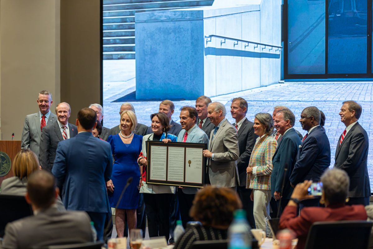 Nick Saban accepts a copy of the resolution naming 'Saban Field' in his honor.