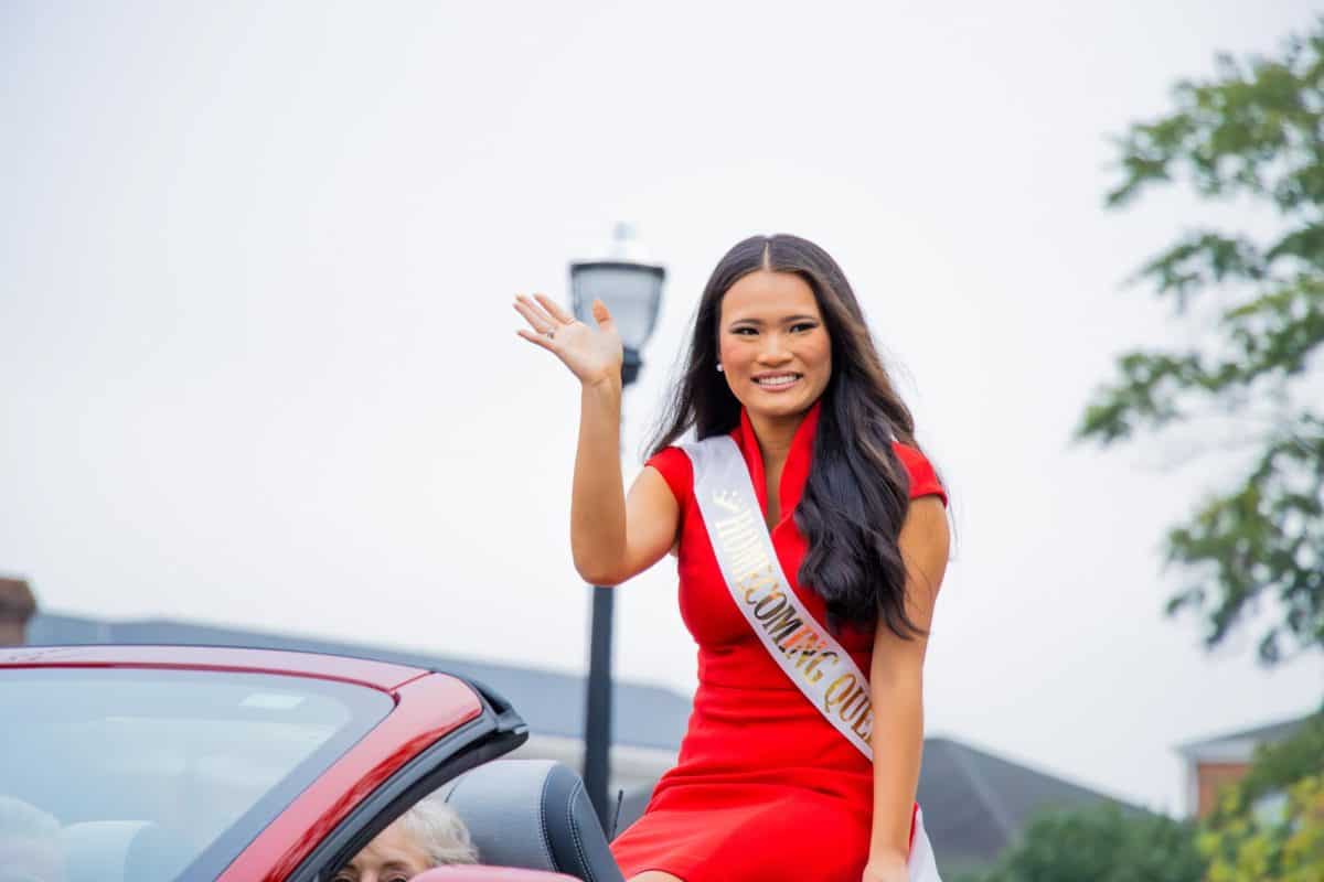 2023 homecoming queen Mae Farmer sits in the back of a car during the parade.