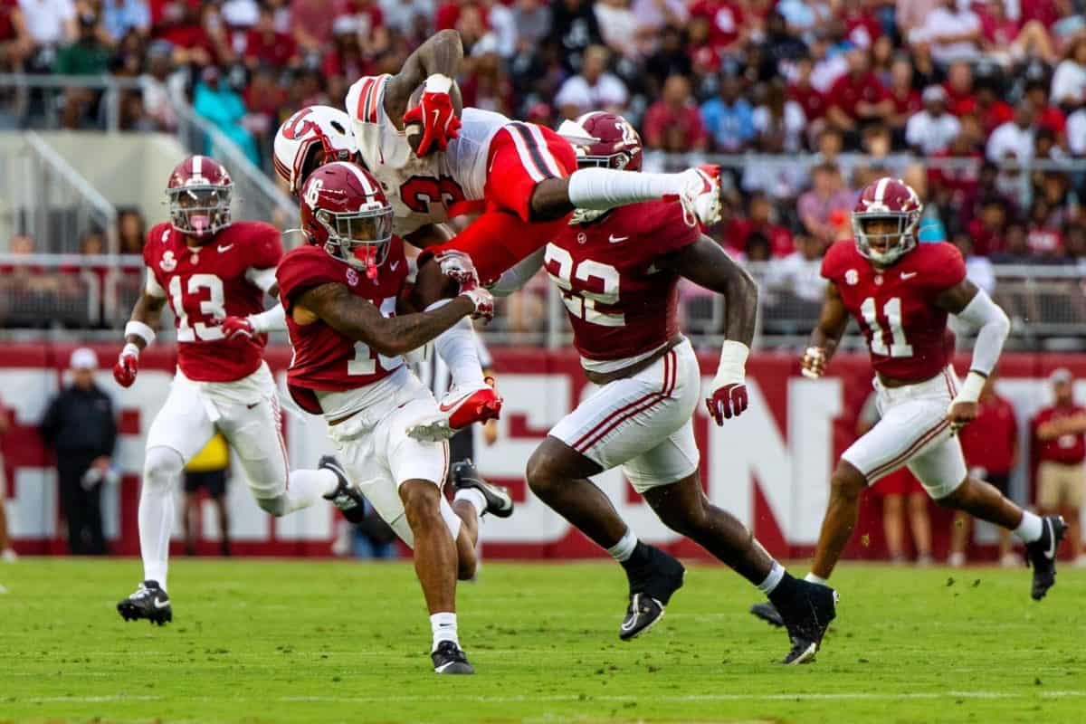 Alabama defensive back Red Morgan (#16) tackles a Western Kentucky player out of the air.