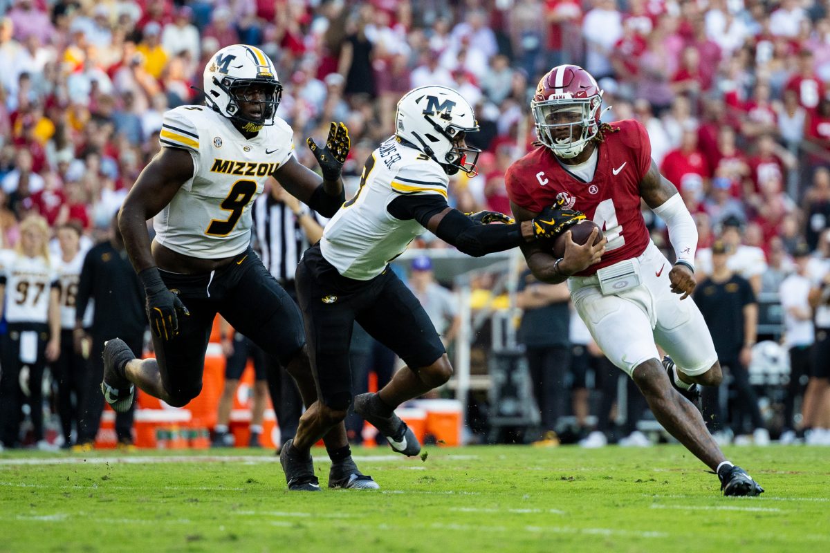 Alabama quarterback Jalen Milroe (#4) runs from Missouri defenders.