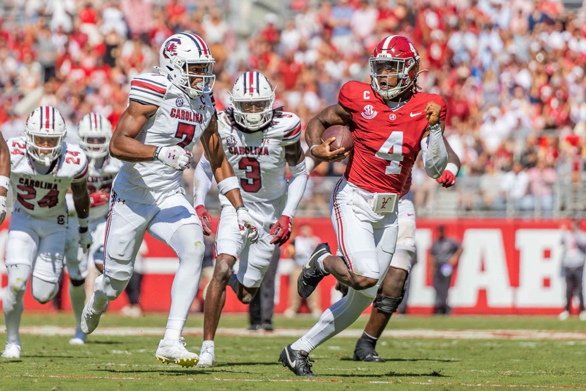 Alabama quarterback Jalen Milroe (#4) runs from South Carolina defense. 