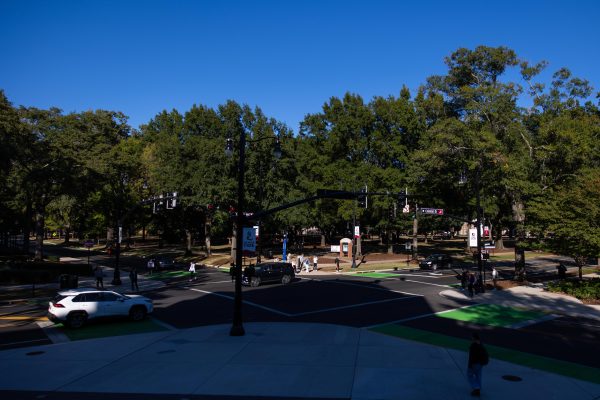 Cars drive through an intersection in front of Reese Phifer Hall.