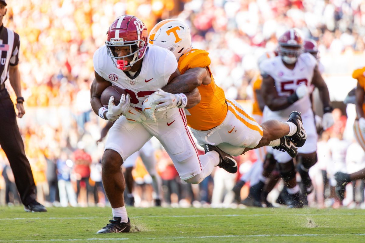 Alabama running back Justice Haynes (#22) runs as a Tennessee defender attempts to complete a tackle.