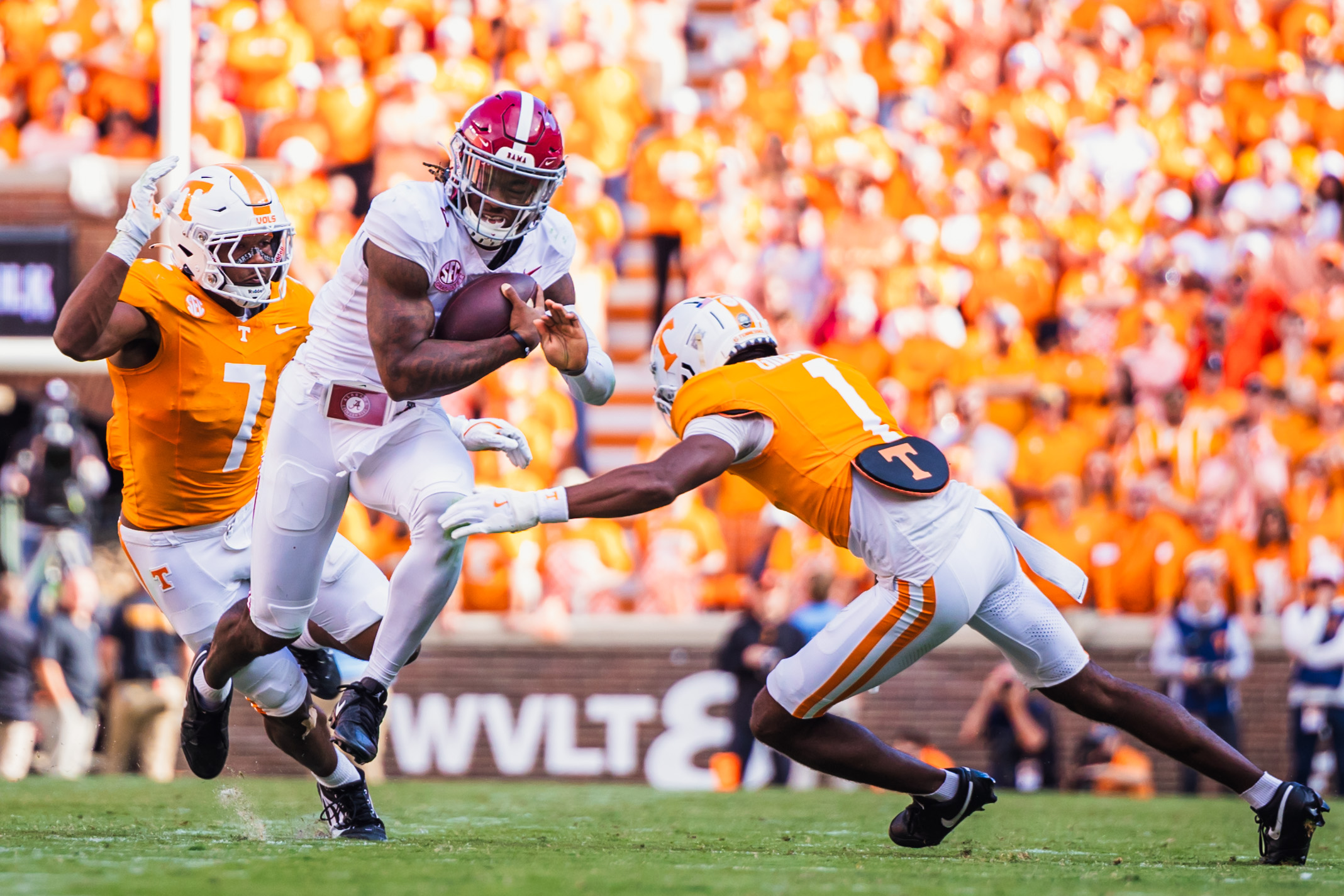 Alabama quarterback Jalen Milroe (#4) attempts to escape Tennessee defenders.