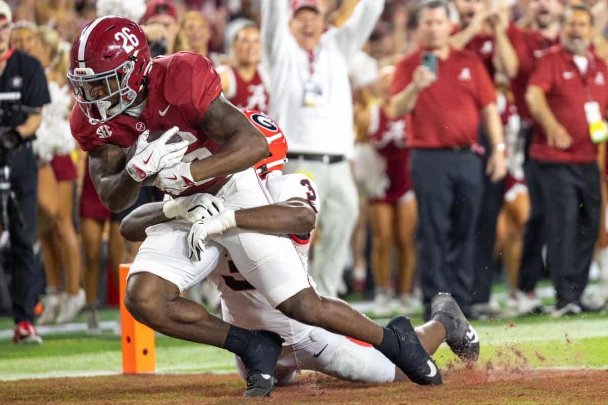 Alabama running back drags a Georgia player into the end zone for a touchdown.