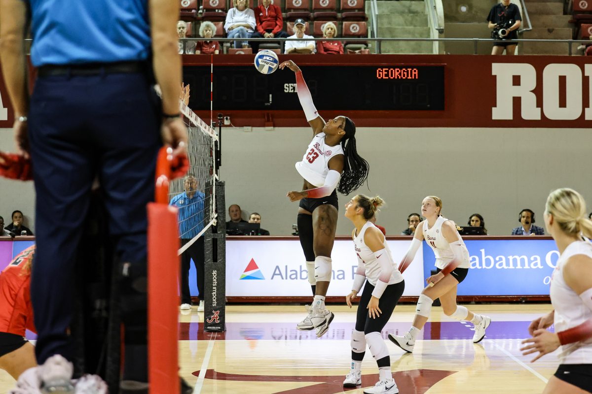 Alabama volleyball player Chaise Campbell (#23) jumps to spike the ball against Georgia.