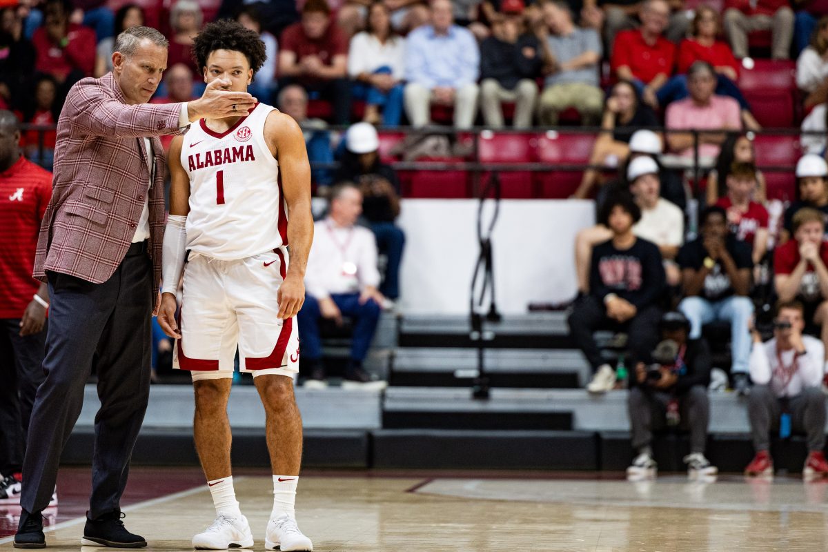 Alabama basketball head coach Nate Oats speaks with guard Mark Sears (#1).