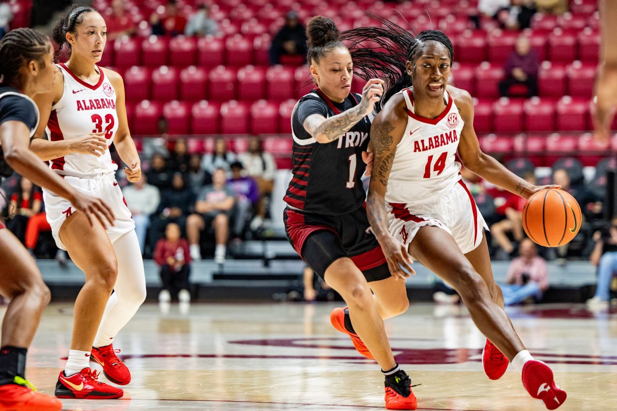 Alabama guard Zaay Green (#14) pushes down the court against a Troy defender.