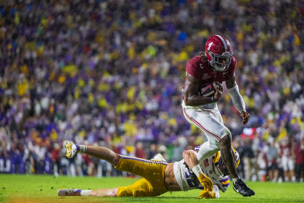 Alabama quarterback Jalen Milroe (#4) escapes LSU defender to score a touchdown.