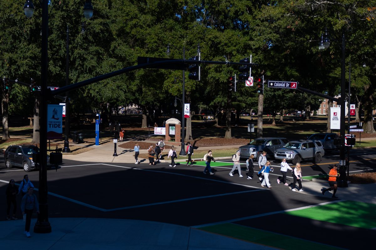 Students walk across the street in front of Reese Phifer Hall.aq