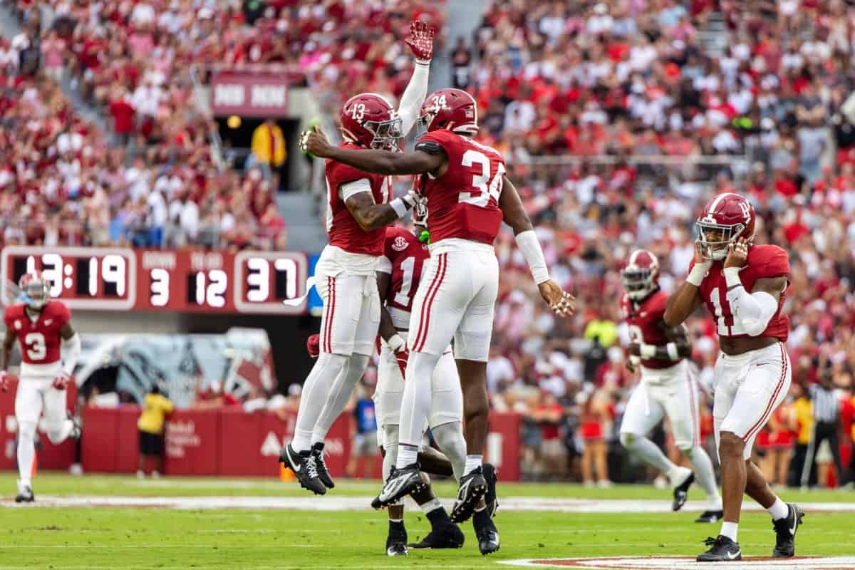 Alabama linebacker Que Robinson (#34) celebrates with defensive back Malachi Moore (#13) after a play.