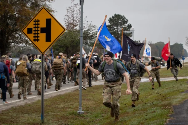 Alabama and Auburn University cadets run around the formation with service flags, Nov. 27, 2024, to boost morale during Operation Iron Ruck. Operation Iron Ruck is an annual event hosted by the Auburn Student Veterans Association (ASVA) and the University of Alabama Campus Veterans Association (CVA) that takes place in the days preceding the Alabama vs Auburn college football game, also known as the Iron Bowl, to raise awareness and funds for veteran suicide prevention.