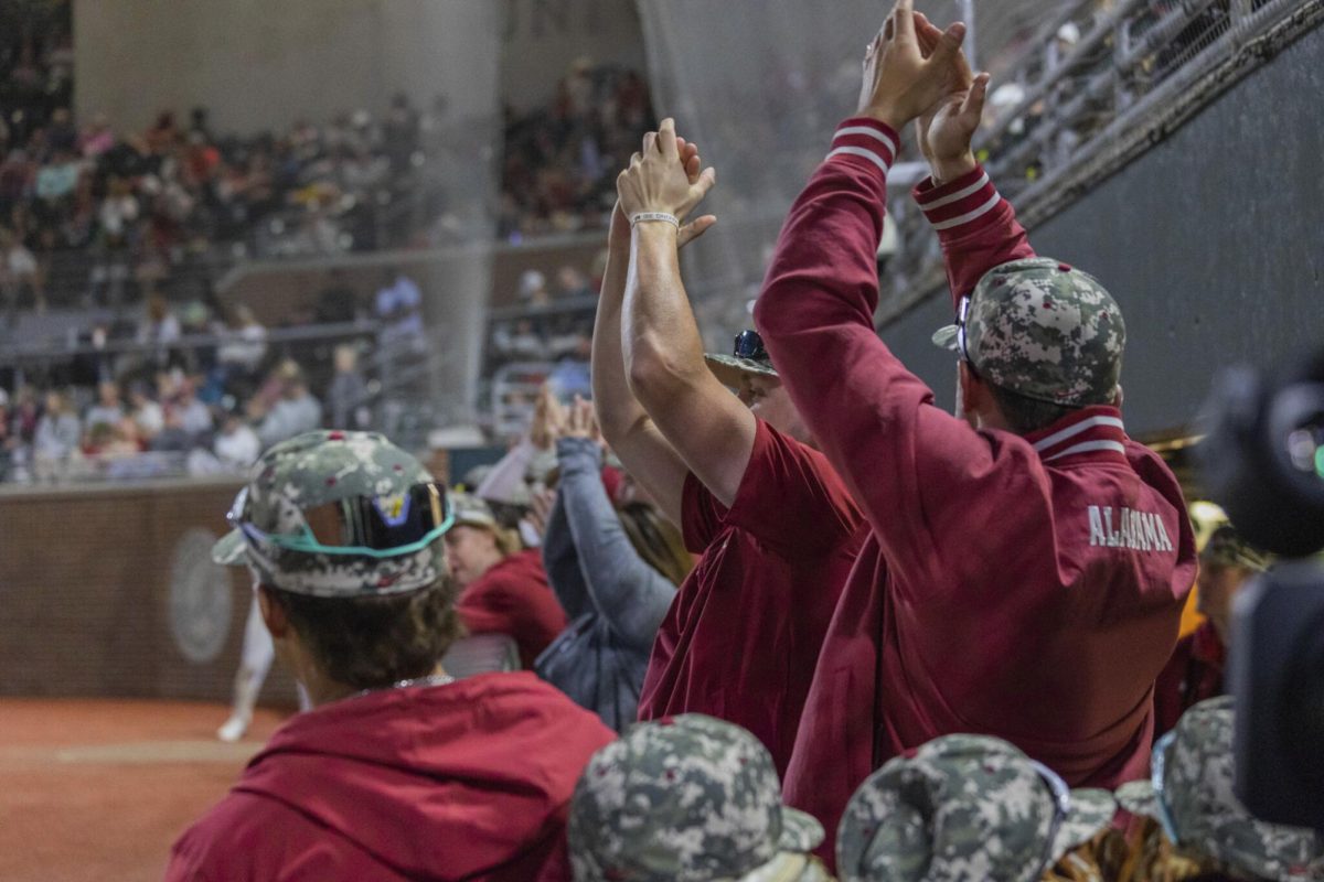 CW// Hannah Grace Mayfield, Players in the Alabama dugout celebrate during a 2024 game versus Arkansas.