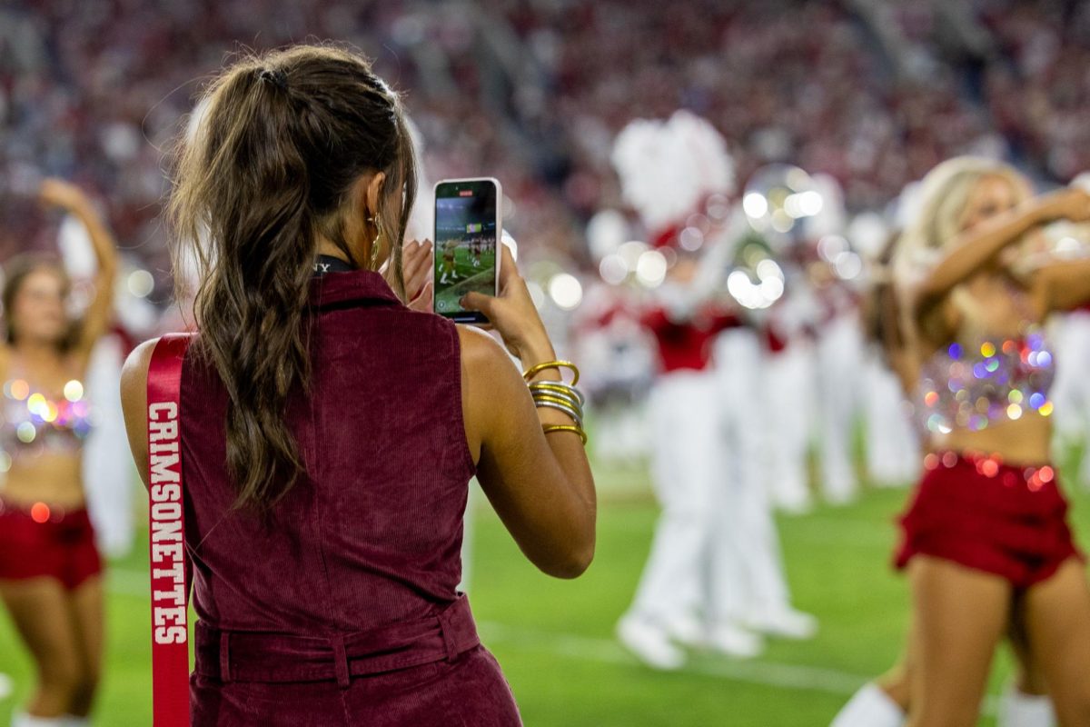 Assistant Crimsonette Coach Colby Horst records videos of the Crimsonettes performing a halftime show. 