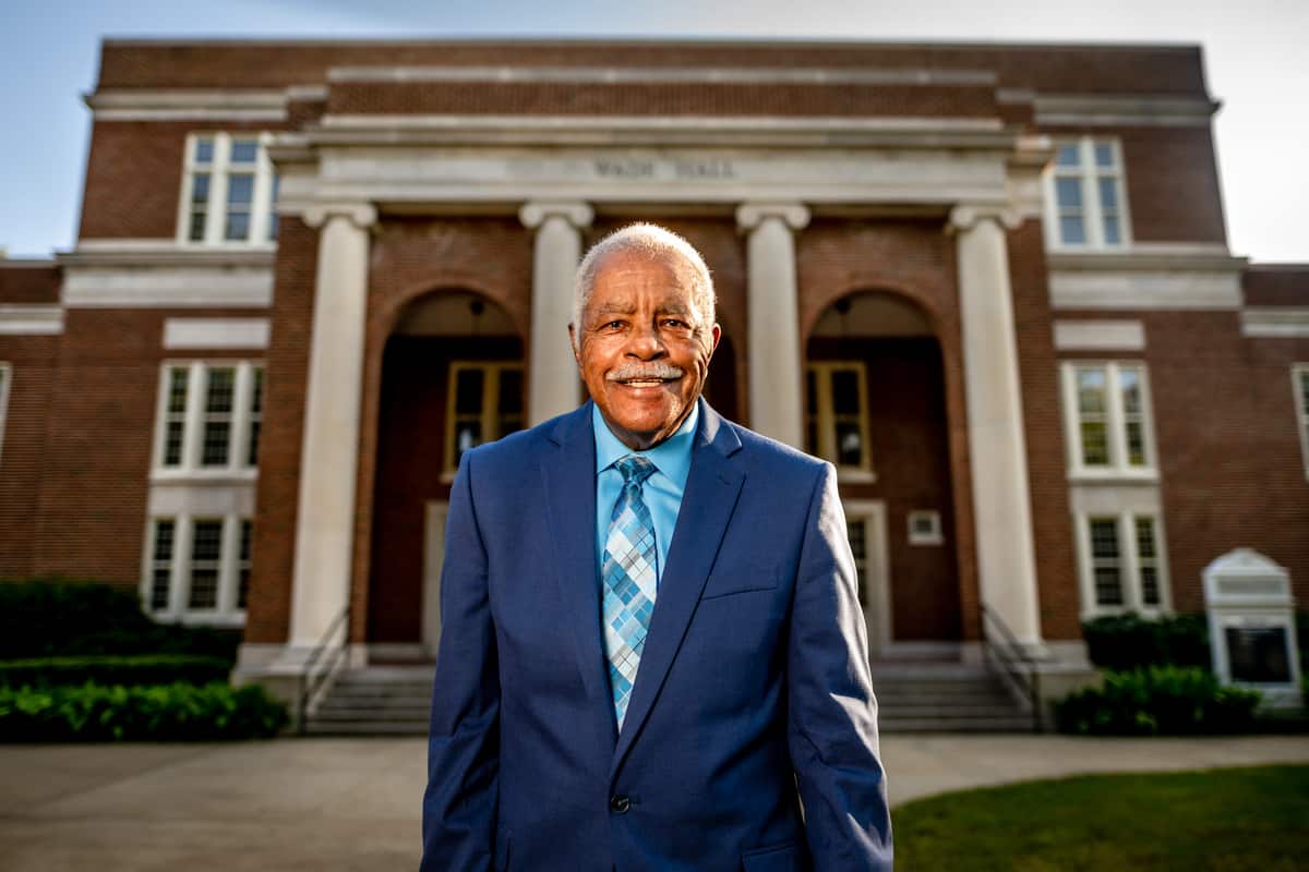 Archie Wade standing in front of Wade Hall, a campus building named after him.