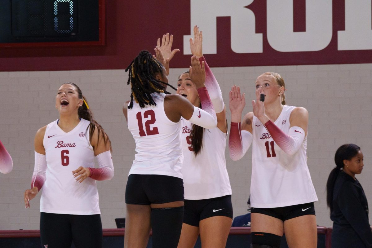 Alabama volleyball players celebrate after a play against Vanderbilt. 