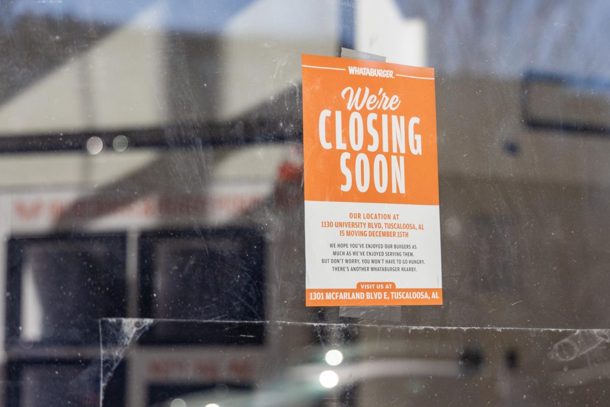 A closing sign hangs in the window at Whataburger. 