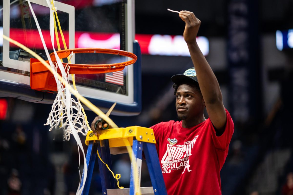 Alabama center Charles Bediako cuts down the net after winning the SEC tournament championship over Texas A&M on March 12, 2023, in Nashville, TN.