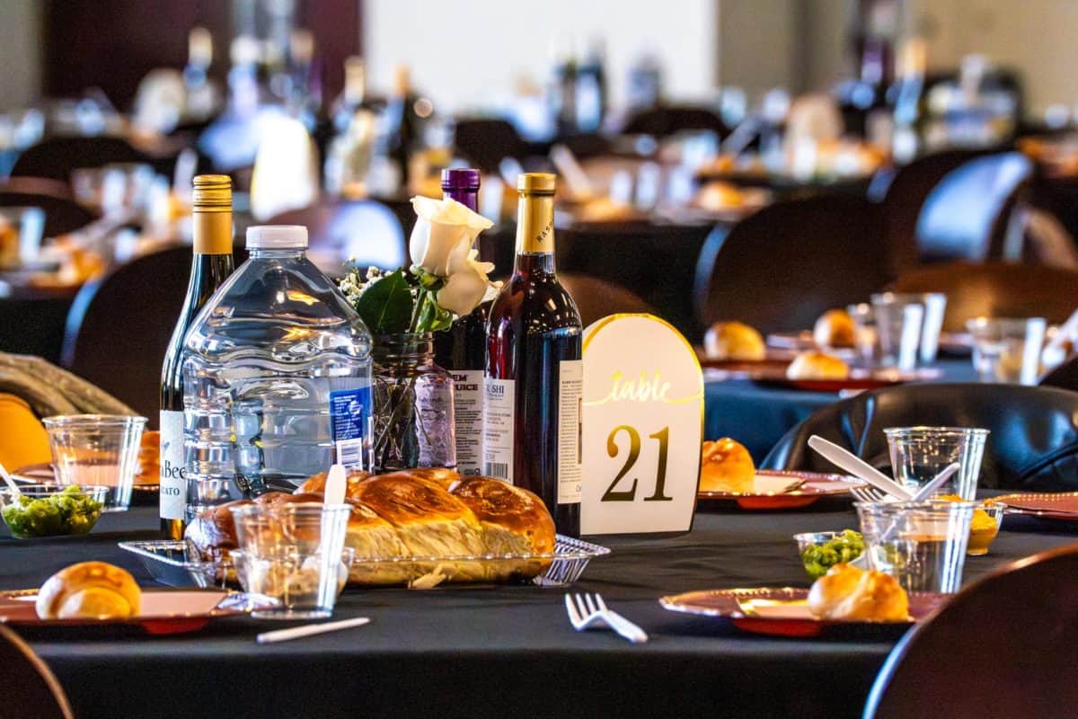 Tables are set with grape juice, wine and challah bread at "Mega Shabbat" on Feb. 6, 2026.