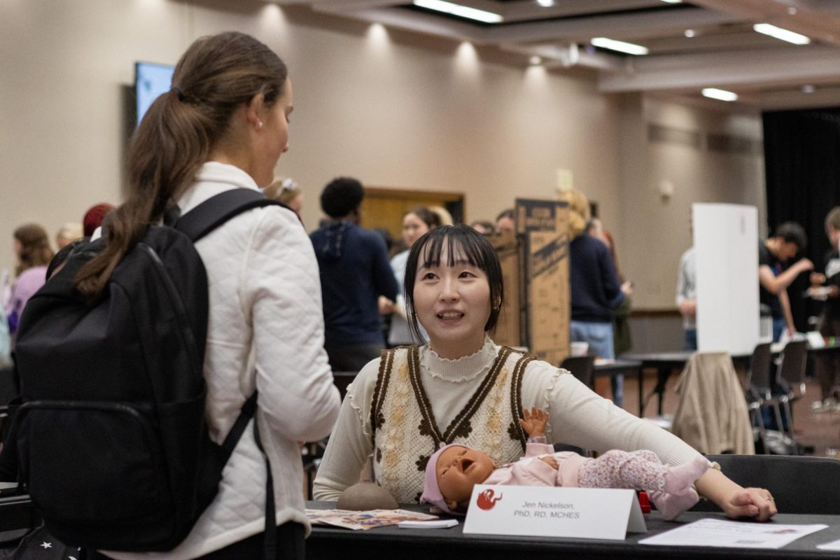 A faculty research assistant for Jen Nickelson speaks to a student at the Faculty Research Showcase on Oct. 28, 2025, in the Student Center Ballroom.