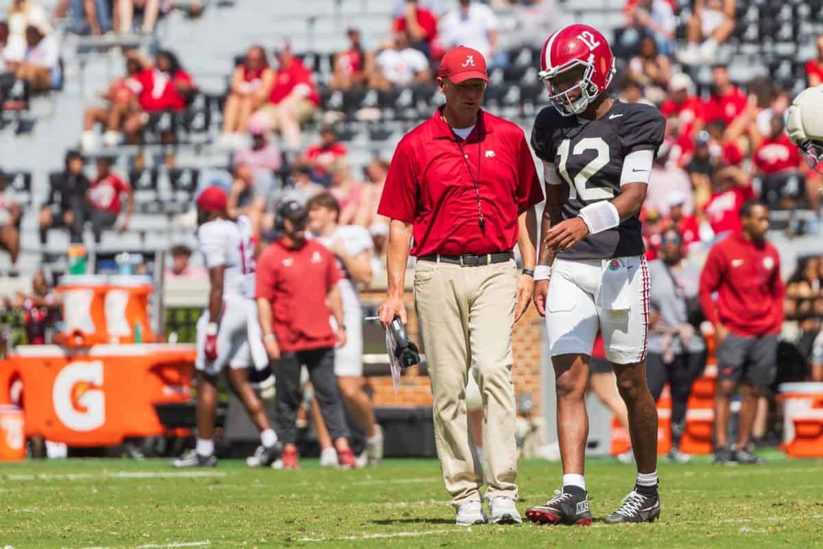 Alabama head coach Kalen DeBoer talks to quarterback Keelon Russell (#12) during practice.