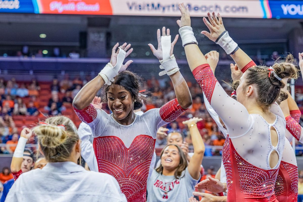 The Alabama gymnastics team celebrates after Azaraya Ra-Akbar's routine against Auburn on Feb. 20, 2026, in Auburn, Alabama.